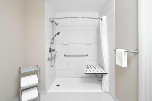 uma casa de banho branca com um chuveiro e um WC. em DoubleTree Suites by Hilton Charlotte/SouthPark em Charlotte