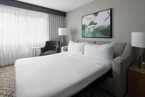 DoubleTree Suites by Hilton Charlotte/SouthPark في تشارلوت: سرير أبيض كبير في غرفة الفندق