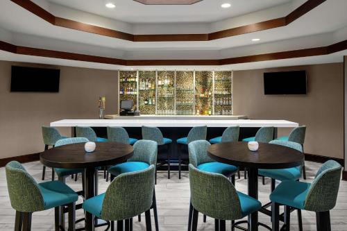 a bar with blue chairs and tables in a restaurant at DoubleTree Suites by Hilton Charlotte/SouthPark in Charlotte