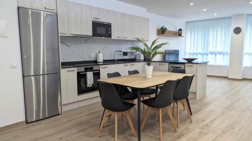 a kitchen with a wooden table and black chairs at Hydros in Ripoll