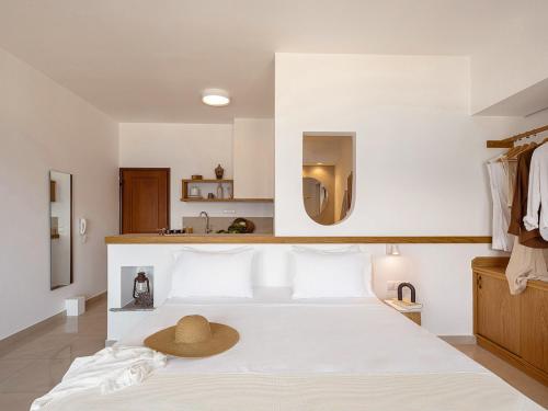 a bedroom with a white bed with a hat on it at Porto Kaza in Sitia