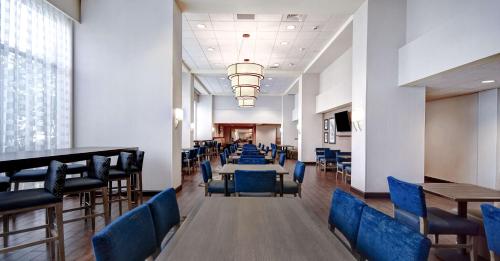 ein Esszimmer mit blauen Stühlen und Tischen in der Unterkunft Hampton Inn & Suites Alexandria Old Town Area South in Alexandria