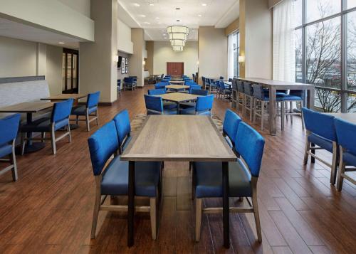 a dining room with tables and blue chairs at Hampton Inn & Suites Alexandria Old Town Area South in Alexandria