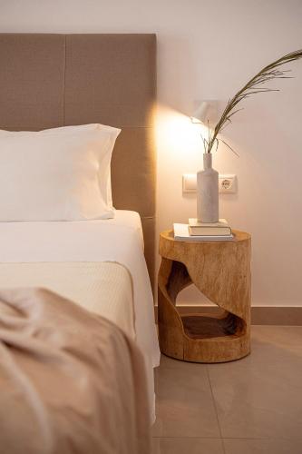 a bedroom with a bed and a table with a lamp at Porto Kaza in Sitia