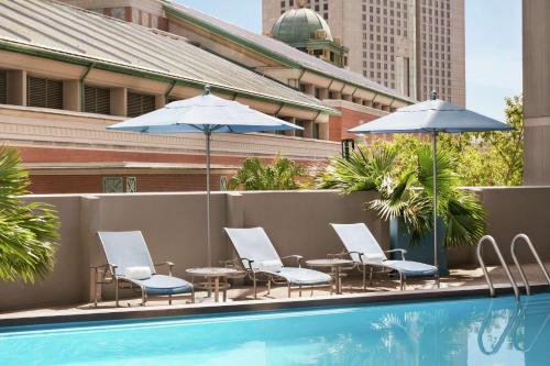 a group of chairs and umbrellas next to a pool at DoubleTree by Hilton New Orleans in New Orleans