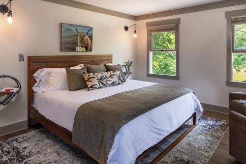 a bedroom with a large bed and two windows at The Inn At Amaris Farms in Weaverville