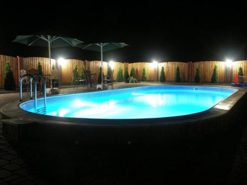 a large swimming pool at night with lights at Dom Gościnny Ola in Darłowo