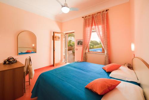 a bedroom with a blue bed and a window at Hotel Villa Sirena in Ischia