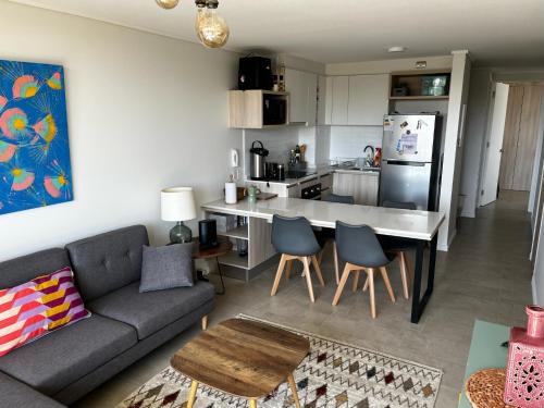 a living room with a couch and a kitchen at Algarrobo Espectacular piso 10 vista bahía in Algarrobo