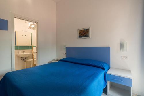a bedroom with a blue bed and a sink at Hotel Villa Sirena in Ischia