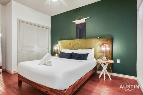 Un dormitorio con una cama grande y una pared verde en Dual Urban Oasis 8BR in Vibrant North Loop Hub, en Austin