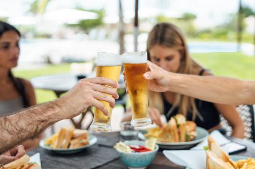 um grupo de pessoas sentadas em torno de uma mesa bebendo cerveja em Hello Villas em Carvoeiro