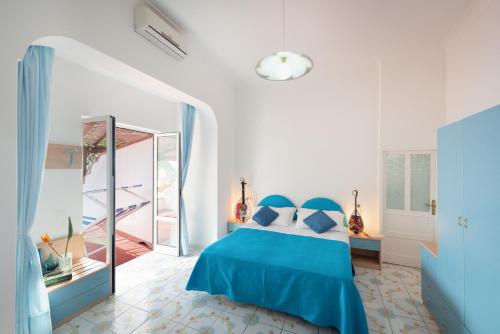 a bedroom with a blue bed and a mirror at Hotel Villa Sirena in Ischia