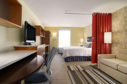 a hotel room with a bedroom with a bed and a desk at Home2Suites Pittsburgh Cranberry in Cranberry Township