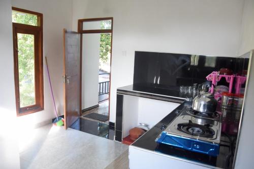 a kitchen with a stove with a tea kettle on it at Green Mart Family Rest in Anuradhapura