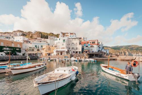 a group of boats in the water with buildings at Hotel Villa Sirena in Ischia