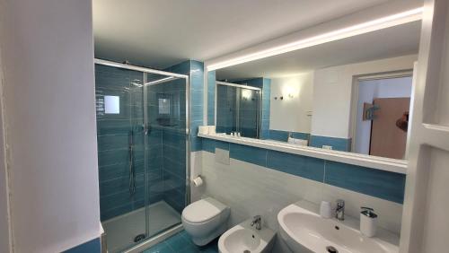 a bathroom with a sink and a toilet and a mirror at Hotel Villa Sirena in Ischia