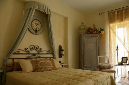 - une chambre dotée d'un lit avec une horloge murale dans l'établissement Serapo Bed & Breakfast, à Gaète