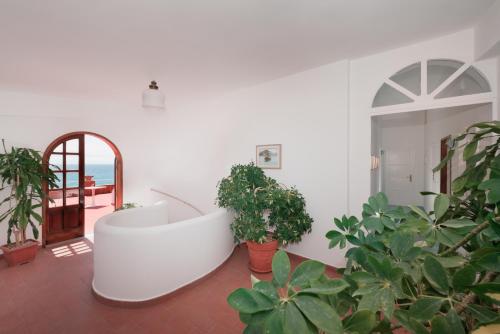 a white bath tub in a room with plants at Hotel Villa Sirena in Ischia