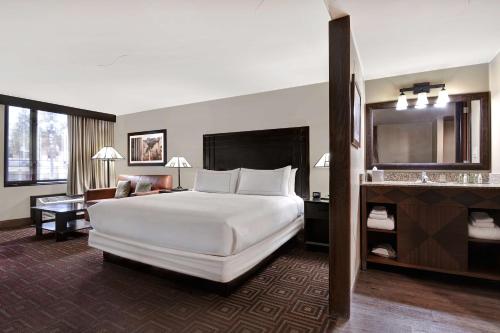 a hotel room with a large white bed and a desk at DoubleTree by Hilton Phoenix- Tempe in Tempe