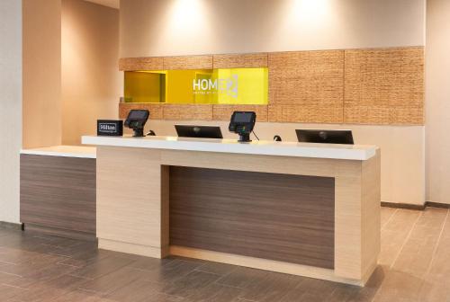 a lobby with two laptops on a counter at Home2 Suites By Hilton Ft. Lauderdale Downtown, Fl in Fort Lauderdale