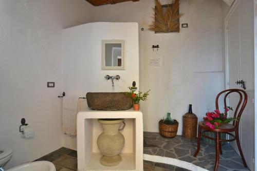 a bathroom with a sink and a vase on a table at Mariangelica in Ginostra