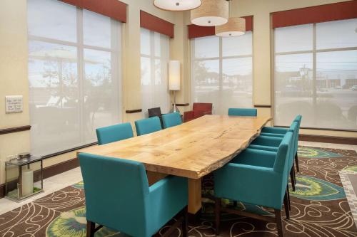 a conference room with a wooden table and blue chairs at Hilton Garden Inn Odessa in Odessa