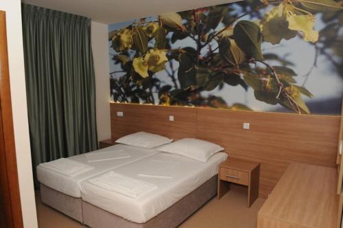 a bedroom with a bed with a large painting on the wall at Guest House Ostojić in Međugorje