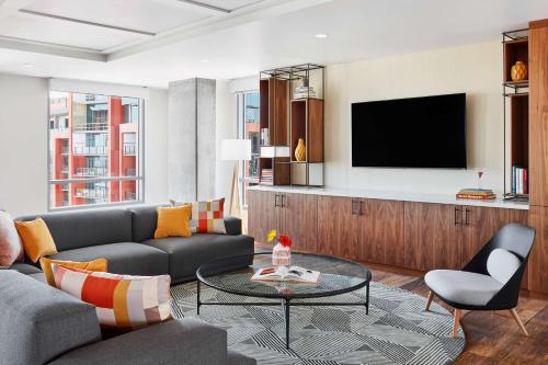 a living room with a couch and a tv at Canopy By Hilton Tempe Downtown in Tempe
