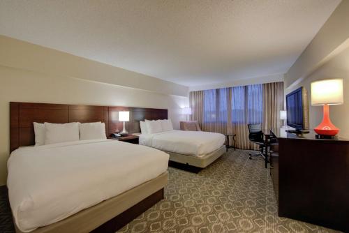 um quarto de hotel com duas camas e uma secretária em DoubleTree by Hilton Atlanta North Druid Hills/Emory Area em Atlanta