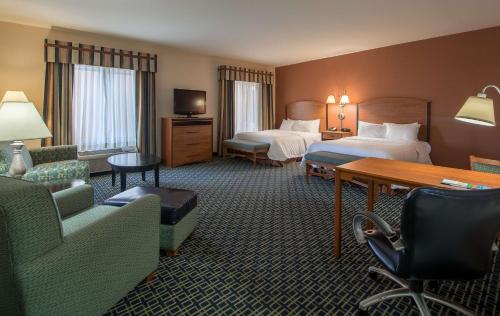 a hotel room with two beds and a desk and chairs at Hampton Inn & Suites Ridgecrest in Ridgecrest