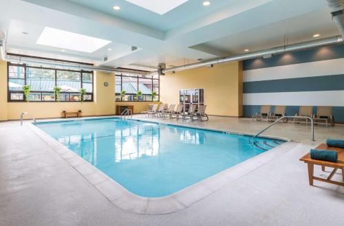 a swimming pool in a large room with chairs and tables at The Saratoga Hilton in Saratoga Springs