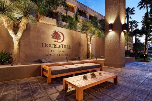 un banc et une table devant un bâtiment dans l'établissement DoubleTree by Hilton Golf Resort Palm Springs, à Cathedral City