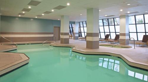 a pool in a building with chairs and a table at Embassy Suites by Hilton Portland Tigard in Tigard