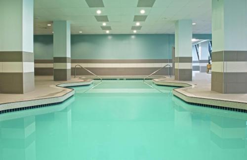 a swimming pool with blue water in a building at Embassy Suites by Hilton Portland Tigard in Tigard