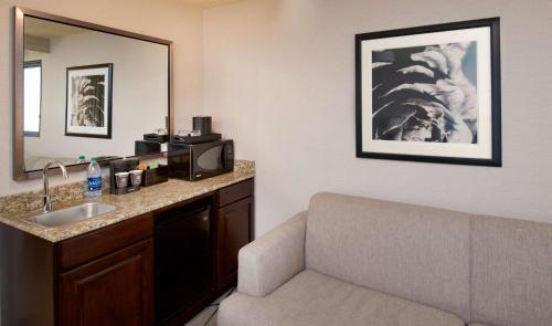 a hotel room with a sink and a microwave at Embassy Suites by Hilton Portland Tigard in Tigard