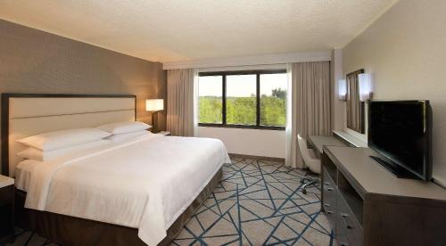 a hotel room with a bed and a flat screen tv at Embassy Suites by Hilton Portland Tigard in Tigard
