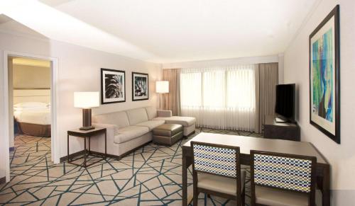 a living room with a couch and a bed at Embassy Suites by Hilton Portland Tigard in Tigard