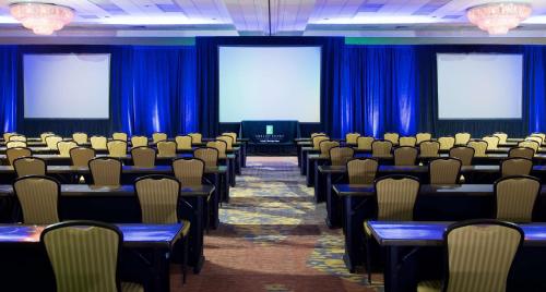 a conference room with blue curtains and tables and chairs at Embassy Suites by Hilton Portland Tigard in Tigard