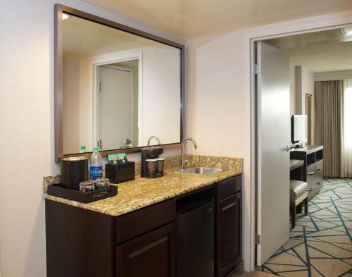 a bathroom with a sink and a large mirror at Embassy Suites by Hilton Portland Tigard in Tigard