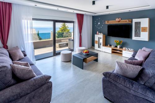 uma sala de estar com dois sofás e uma televisão em Luxury Apartment Lorena - Private Heated Pool - em Jesenice