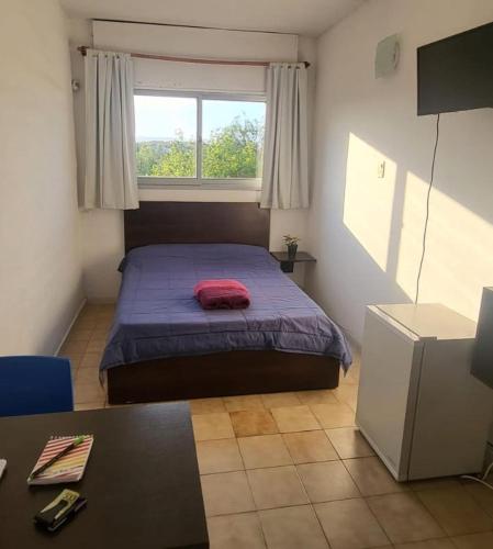 sypialnia z łóżkiem, stołem i oknem w obiekcie Alem B&B w mieście Villa Carlos Paz