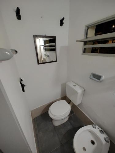 biała łazienka z toaletą i lustrem w obiekcie Alem B&B w mieście Villa Carlos Paz