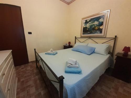 Un dormitorio con una cama con toallas azules. en Lighthouse Gabbiano Azzurro, en Villaggio San Leonardo