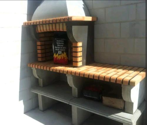 ein Modell eines Pizzaofens mit einer Bank in der Unterkunft Casa dala, en aguiño in Ribeira