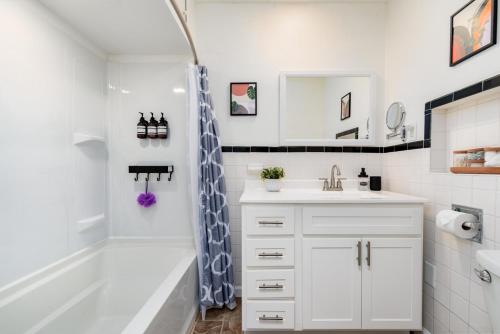 a white bathroom with a tub and a sink at Lovely Landing Pad near Lambert Airport 3 bed bath in Berkeley