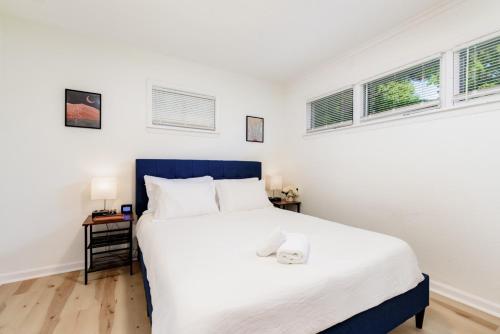 1 dormitorio con 1 cama blanca grande y 2 ventanas en Lovely Landing Pad near Lambert Airport 3 bed bath, en Berkeley