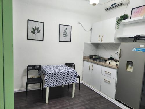 una pequeña cocina con mesa y nevera en Aparthotel Genova en Santo Domingo