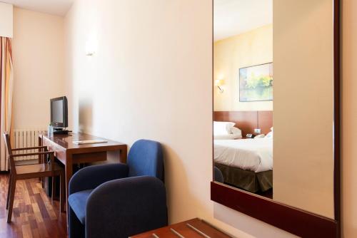 a hotel room with a bed and a mirror at Hotel Maroa Vigo in Vigo