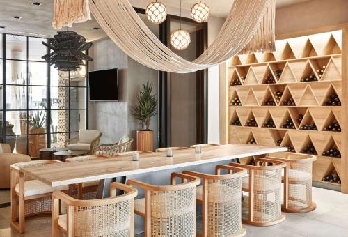 a restaurant with a large wooden table and chairs at Senna House Hotel Scottsdale, Curio Collection By Hilton in Scottsdale